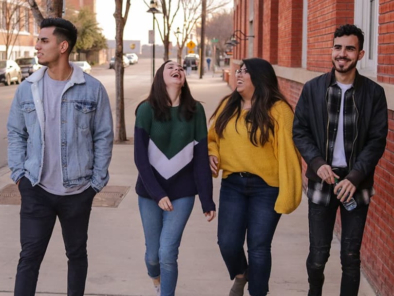 Young adults together down a street